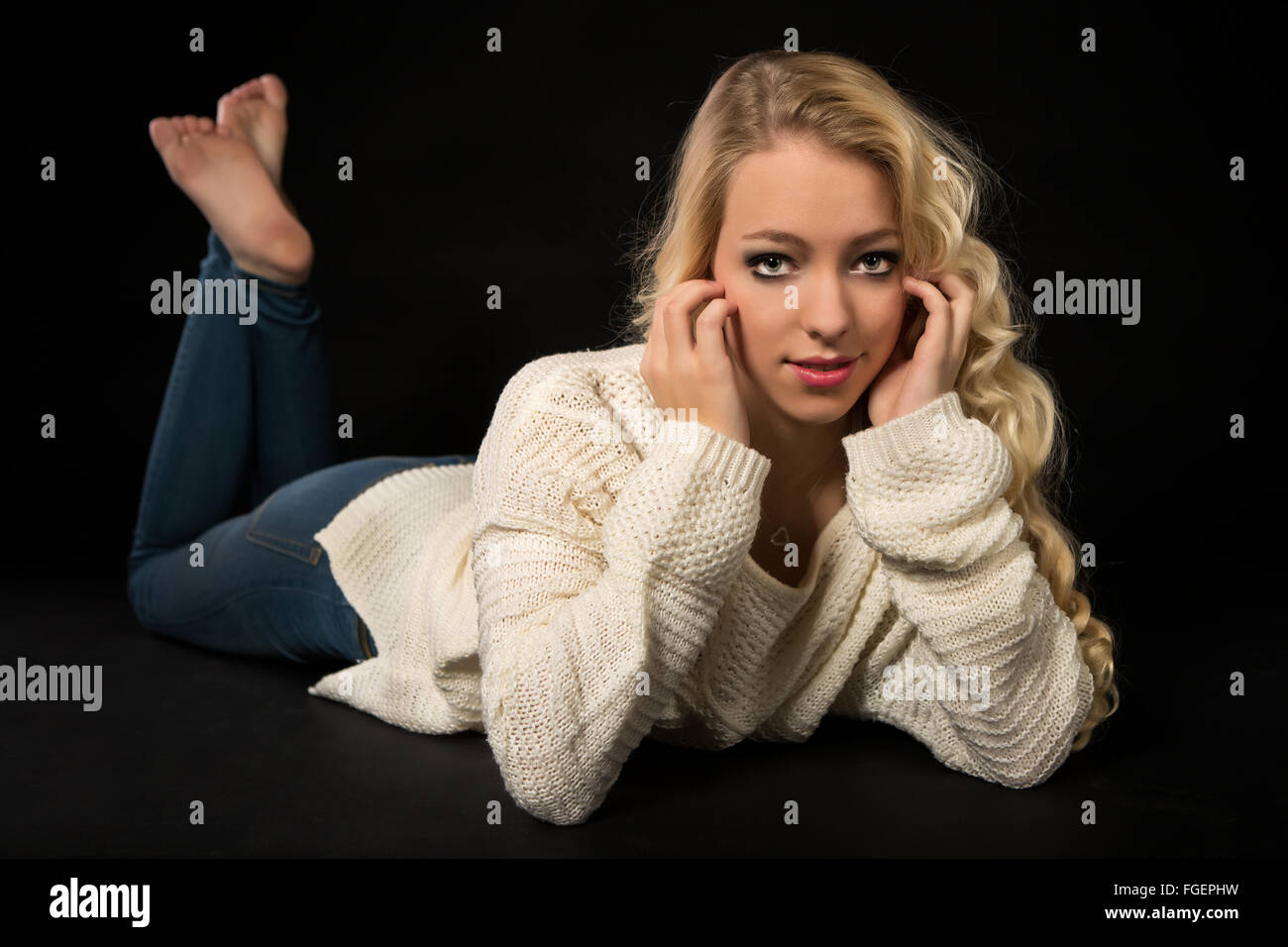 Young blond woman in white sweater Stock Photo