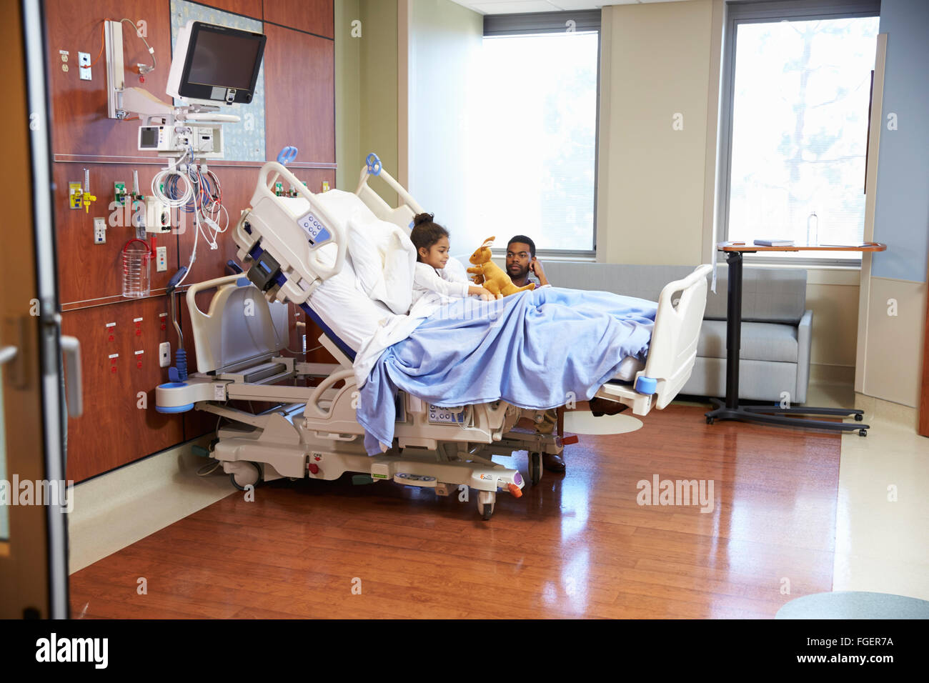 Father With Daughter In Hospital Pediatric Unit Stock Photo