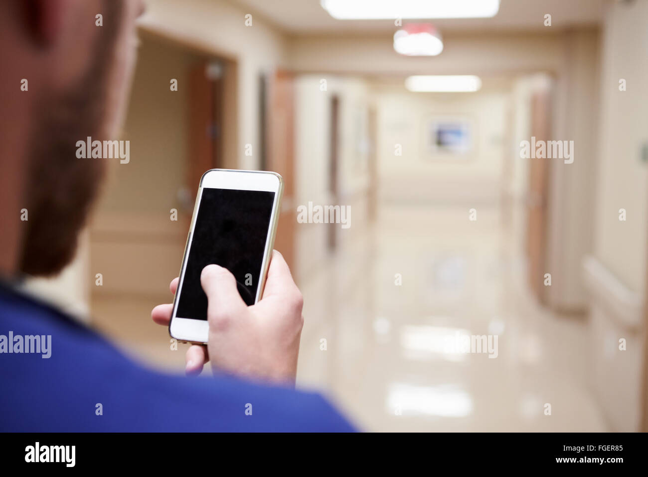 Close Up Of Nurse With Cellphone In Hospital Corridor Stock Photo
