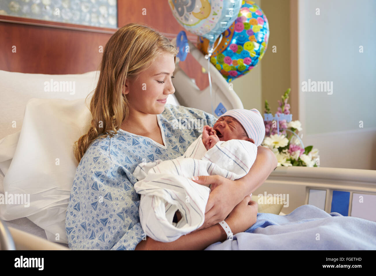 Teenage Girl Holding Newborn Baby Son In Hospital Stock Photo