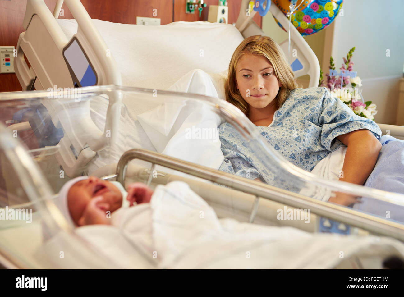 Worried Teenage Girl With Crying Newborn Baby In Hospital Stock Photo