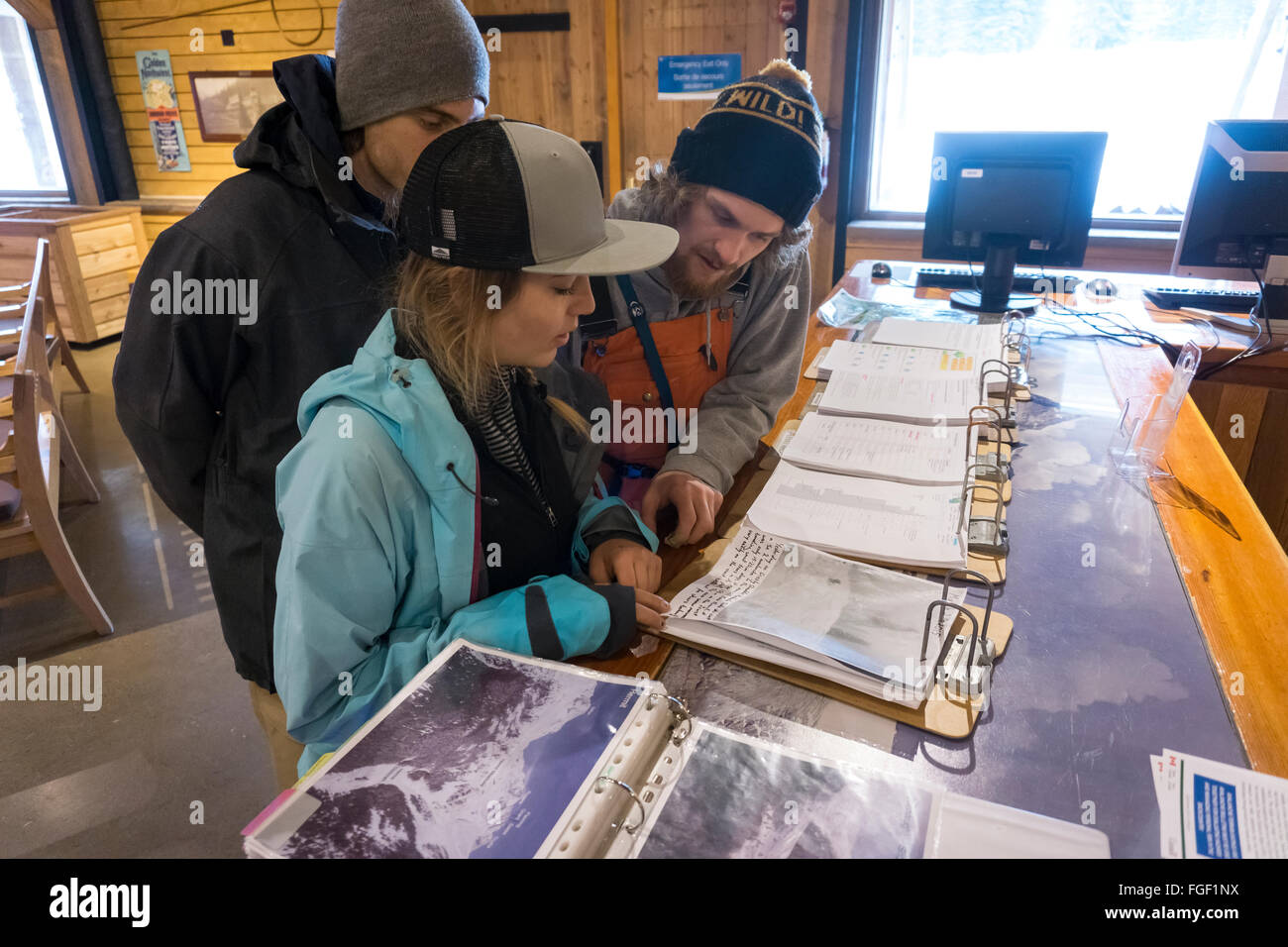A small group of friends lookg  the backcountry avalanche report and forecast  the Glacier Nial Park visitor center  British Stock Photo