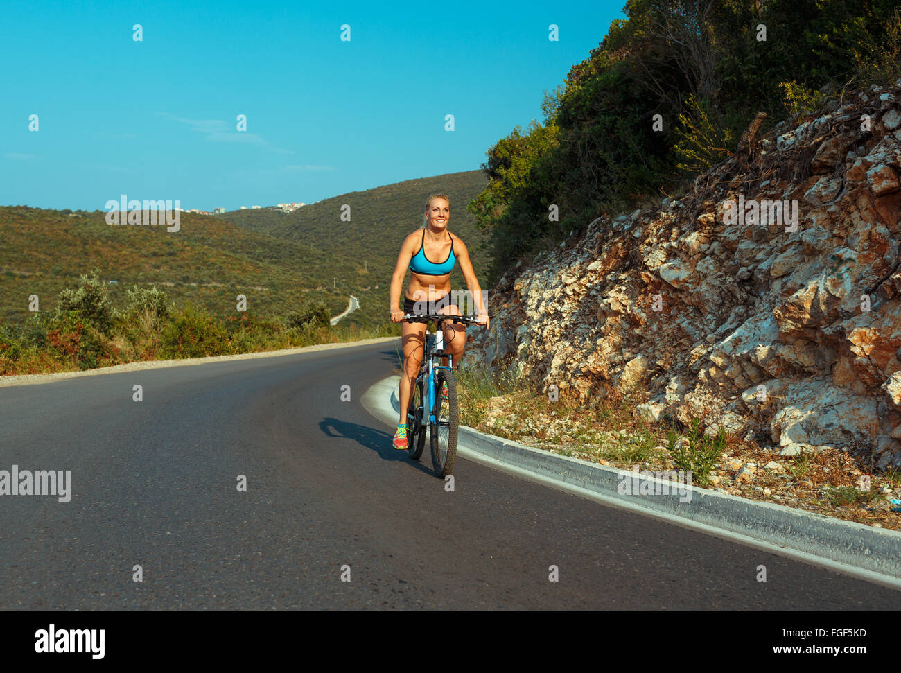 Happy woman cyclist riding a bike on a mountain road Stock Photo Alamy