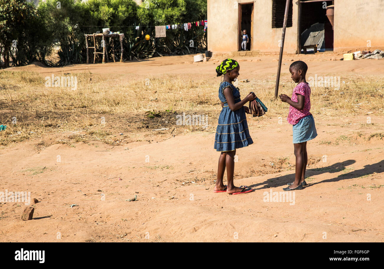 Two girls chat together outside in their Zimbabwean village Stock Photo