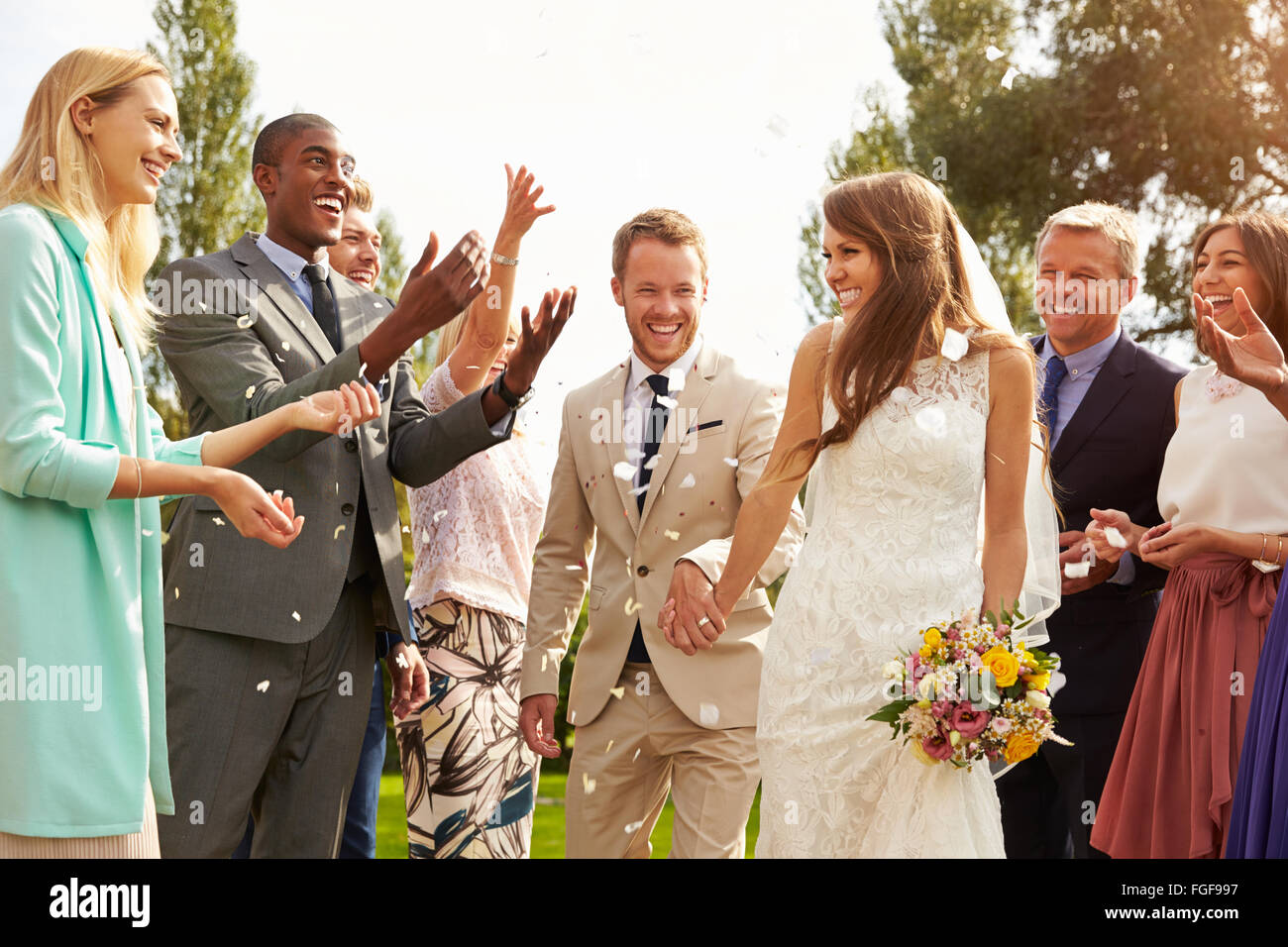 Guests Throwing Confetti Over Bride And Groom At Wedding Stock Photo Alamy