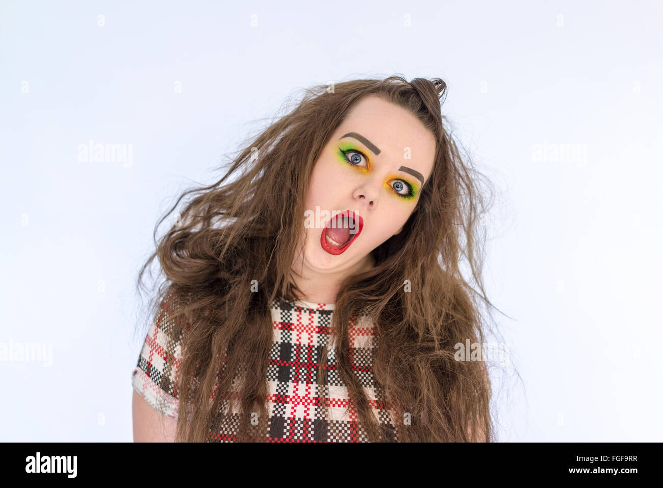Teenage girl with long hair and bright make up screaming Stock Photo