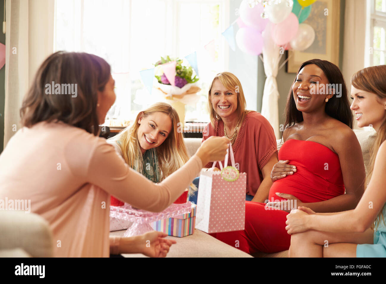 Group Of Female Friends Meeting For Baby Shower At Home Stock Photo