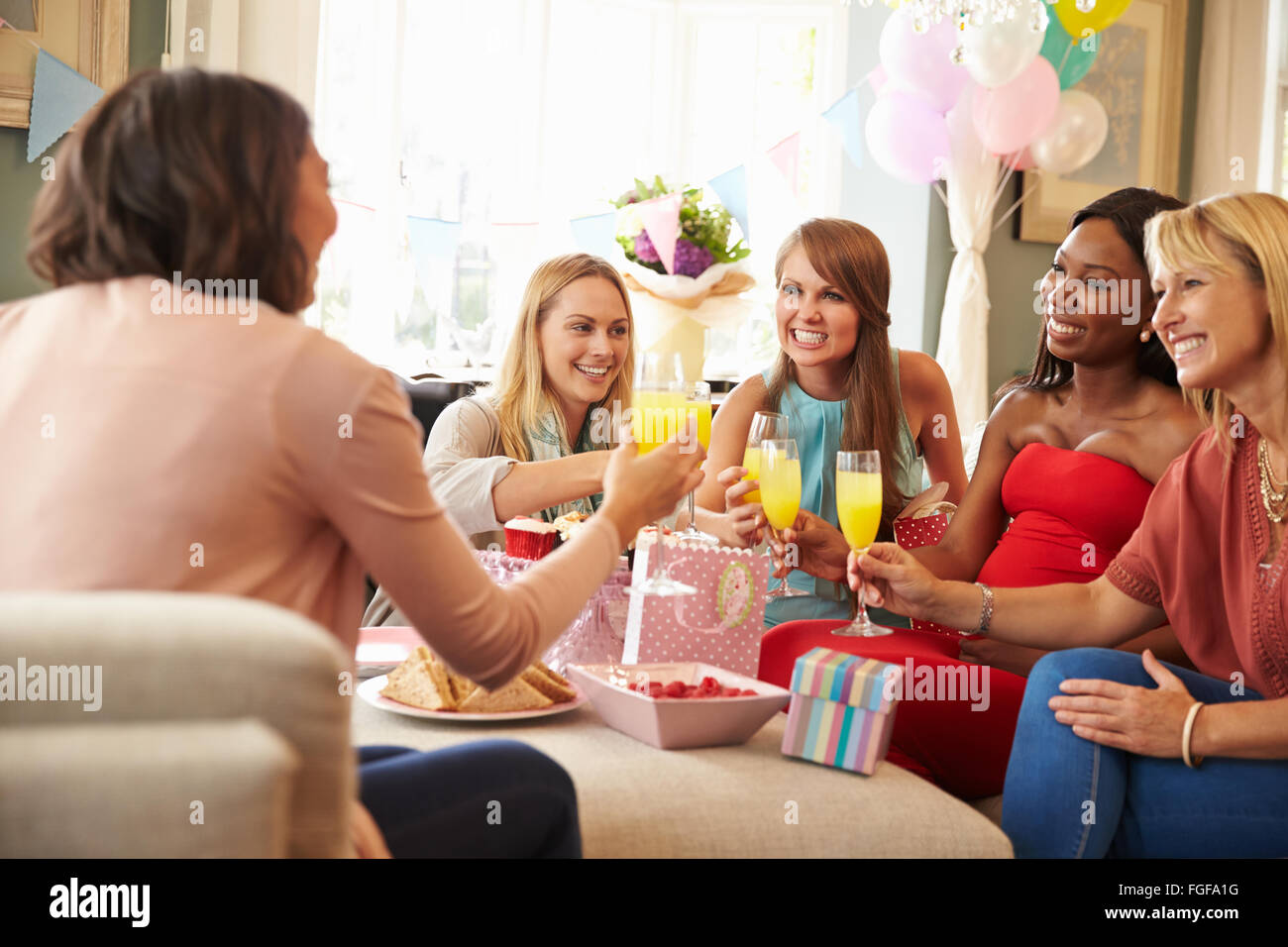 Friends Making A Toast With Orange Juice At Baby Shower Stock Photo Alamy