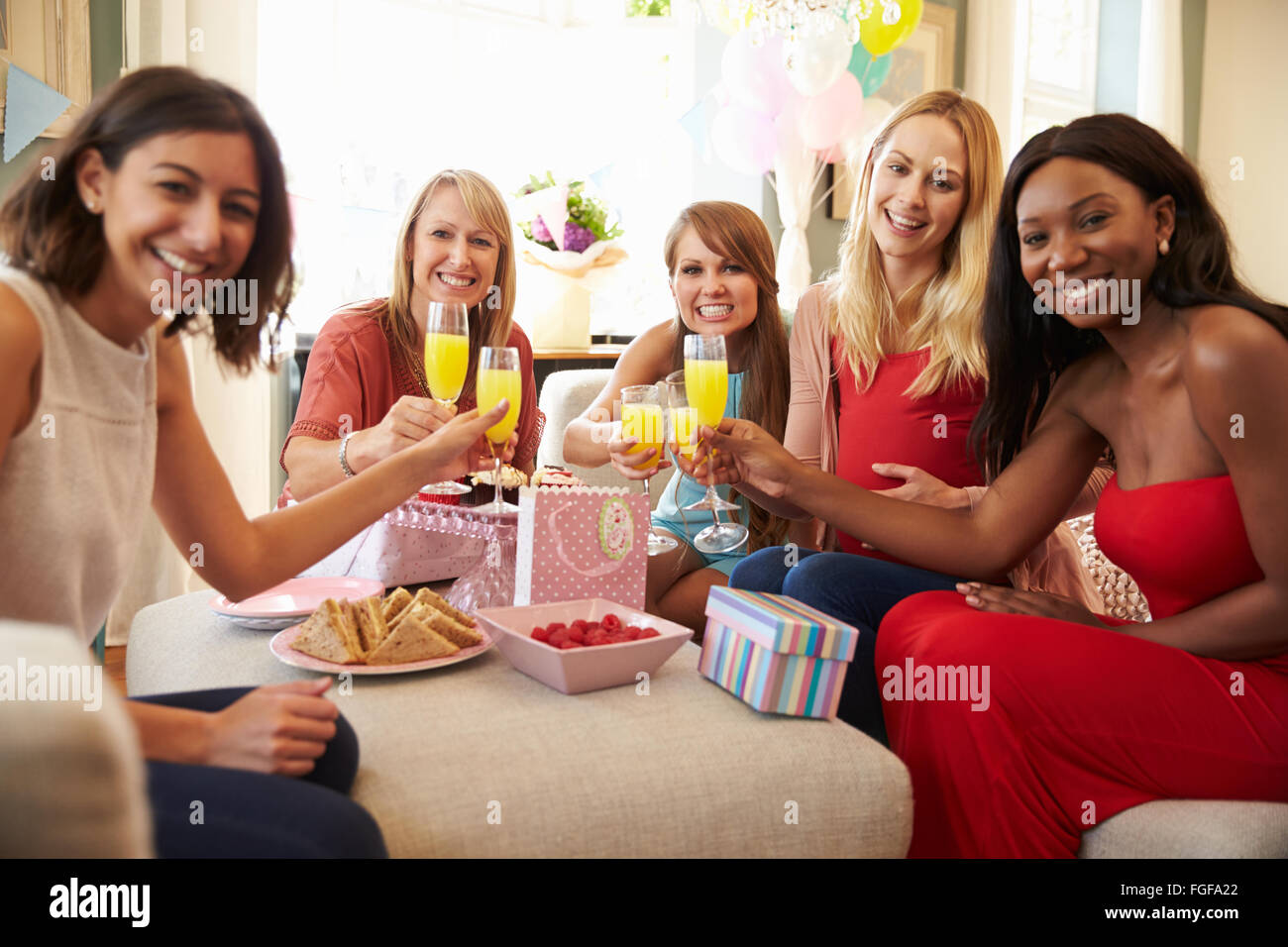 Friends Making A Toast With Orange Juice At Baby Shower Stock Photo Alamy