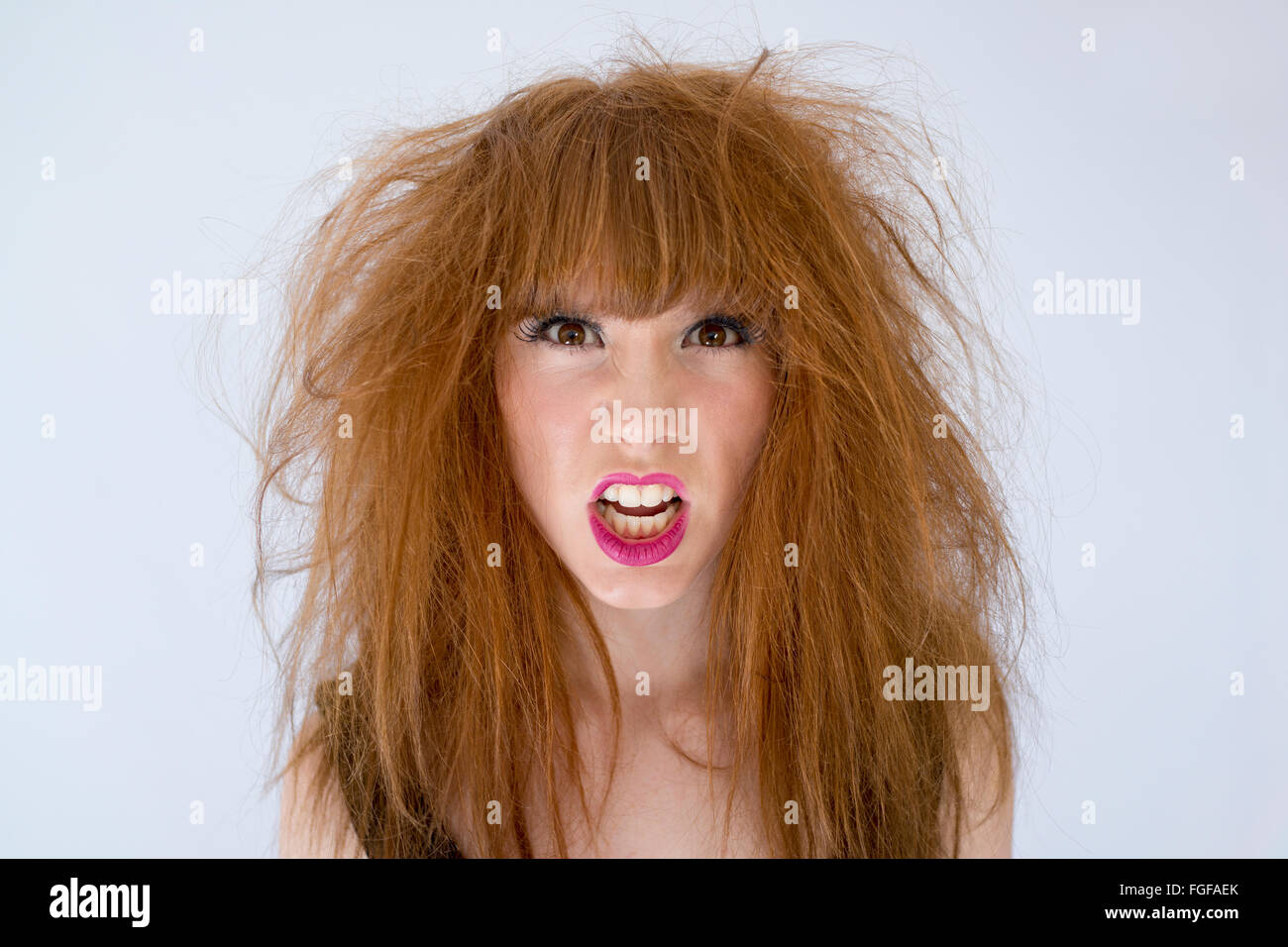 Portrait of a woman with messy disheveled hair with and expression of anger Stock Photo