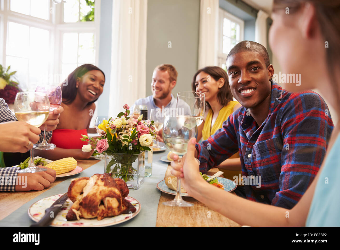 Friends At Home Sitting Around Table For Dinner Party Stock Photo - Alamy