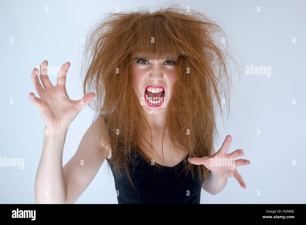 Woman with messy tangled long brown hair about to fight screaming Stock Photo
