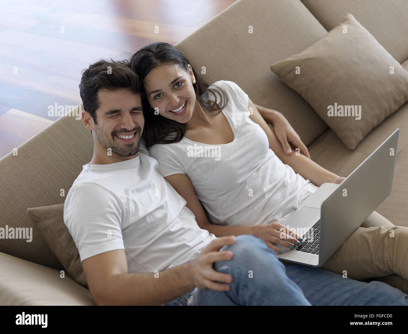 relaxed young couple working on laptop computer at home Stock Photo - Alamy