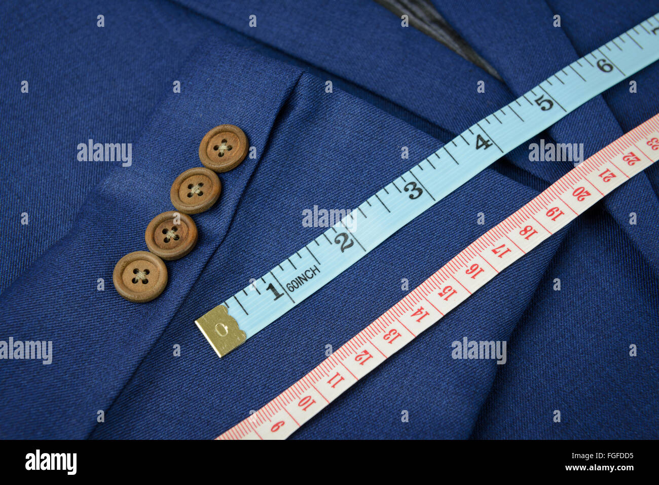 white measurement tape on blue jacket, tailoring Stock Photo