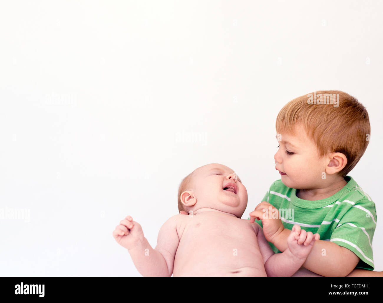 Young boy holding baby sister in arms Stock Photo