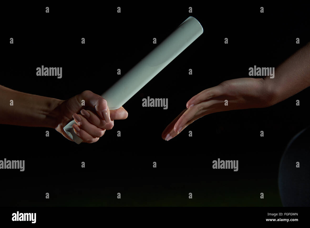 athletic runners passing baton in relay race Stock Photo Alamy