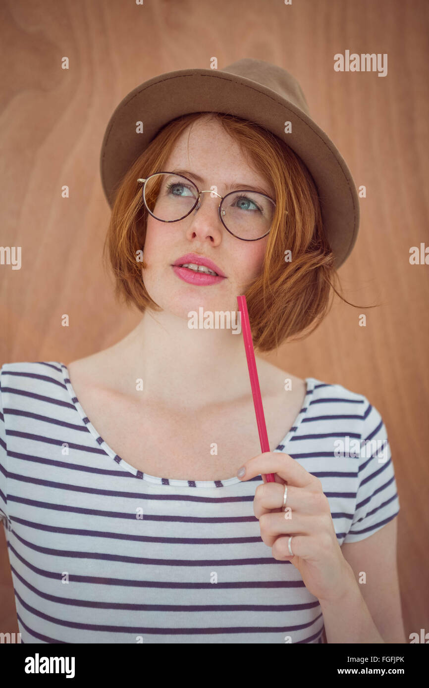 Thoughtful hipster holding pen Stock Photo Alamy
