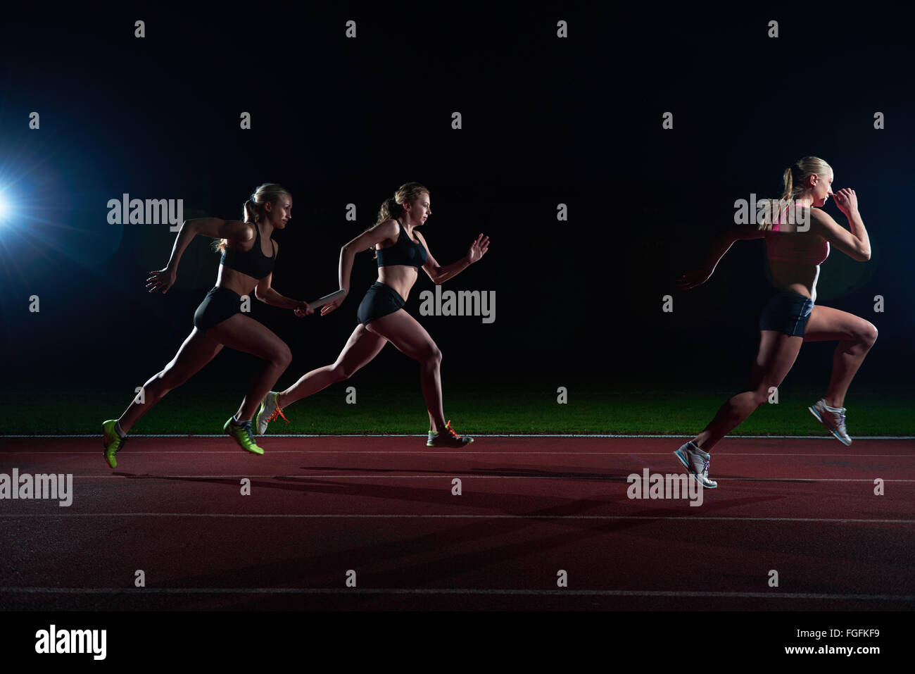 athletic runners passing baton in relay race Stock Photo Alamy