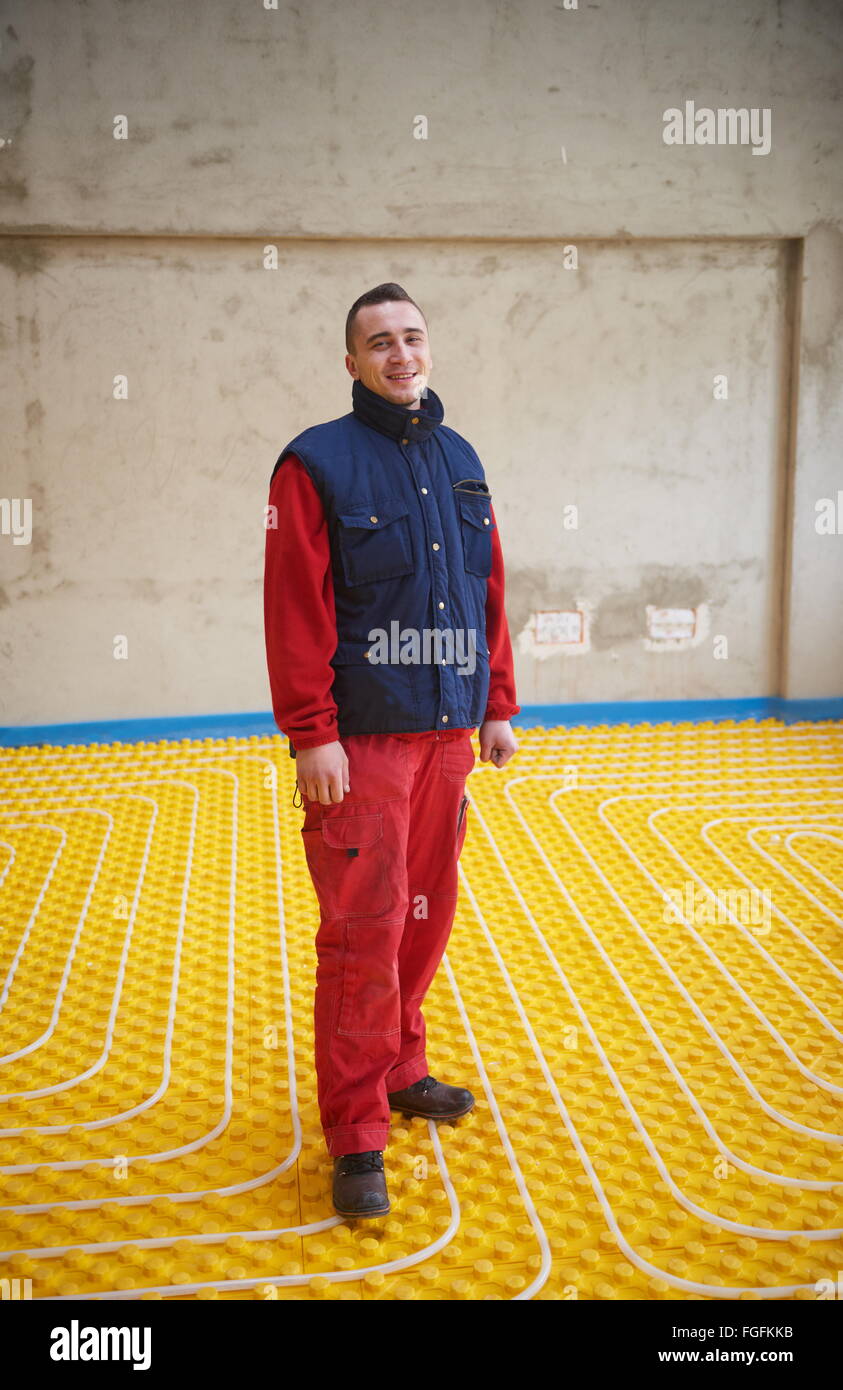 workers installing underfloor heating system Stock Photo Alamy