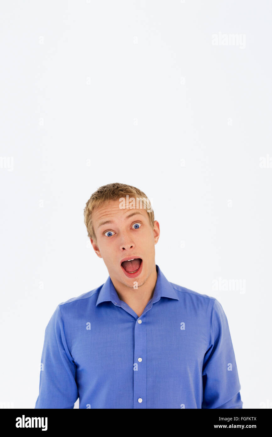Man with blonde hair and blue eyes wearing a blue business shirt shouting Stock Photo