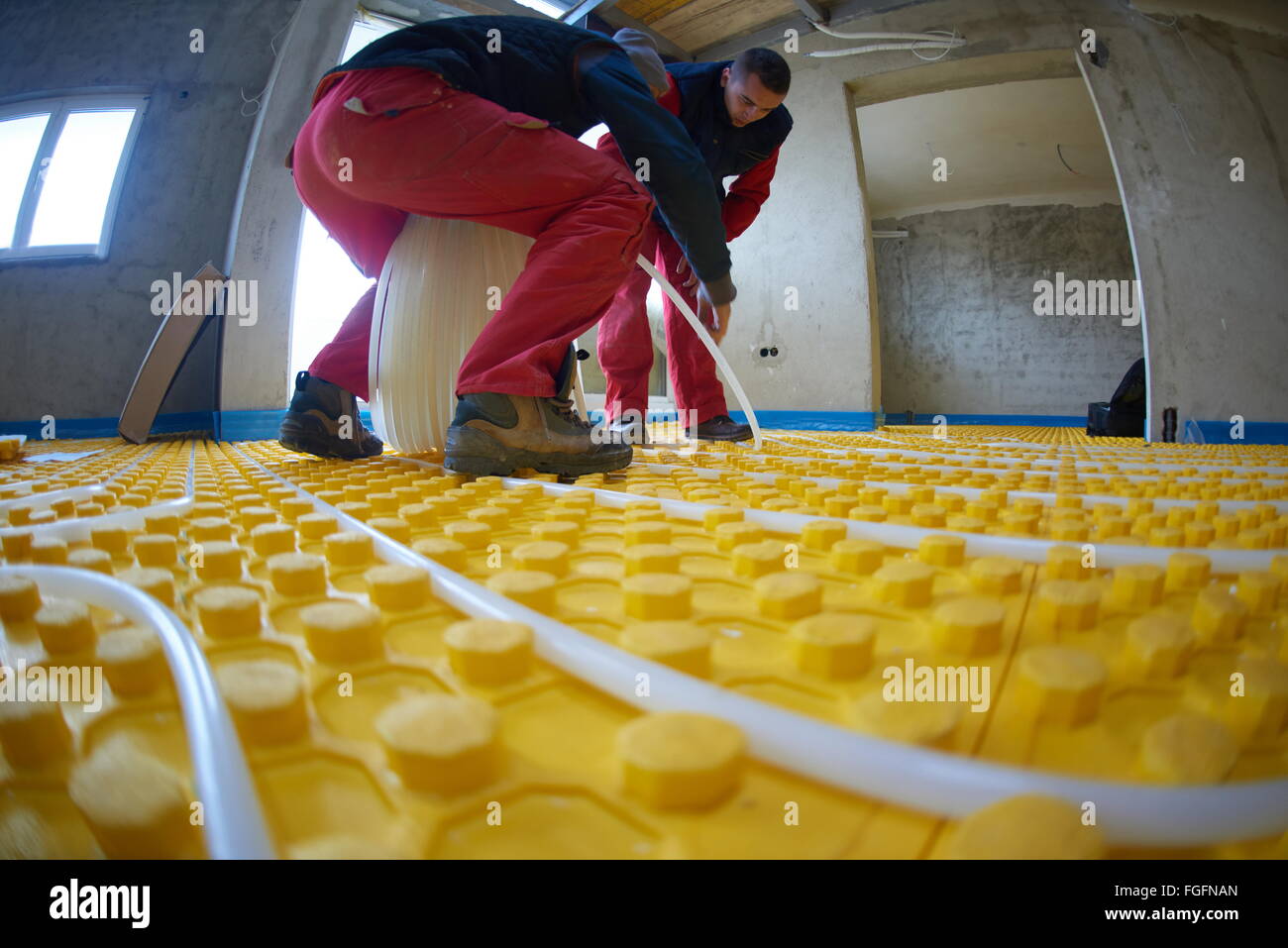 workers installing underfloor heating system Stock Photo Alamy