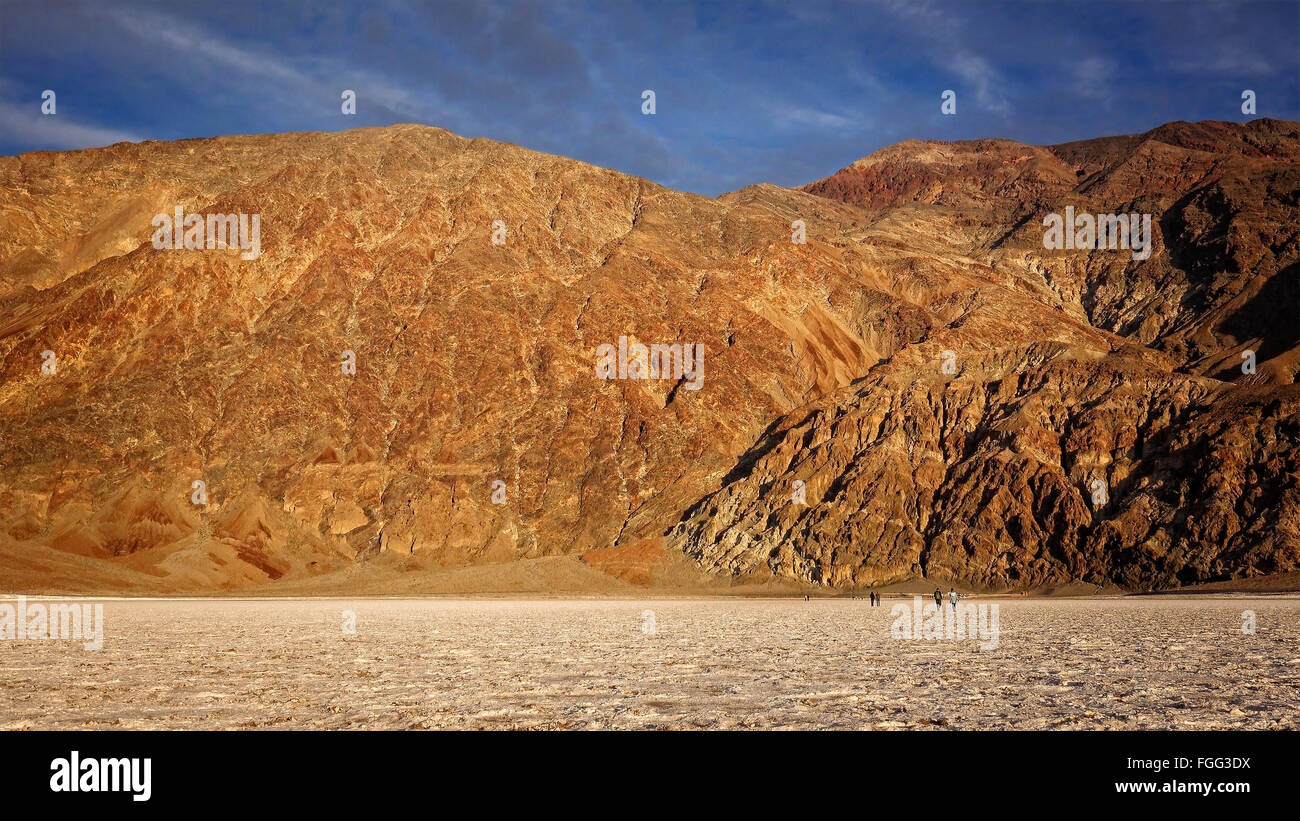 Tourists walk on the salt flats in Badwater Basin in Death Valley National Park. Badwater Basin in the lowest point in North Ame Stock Photo