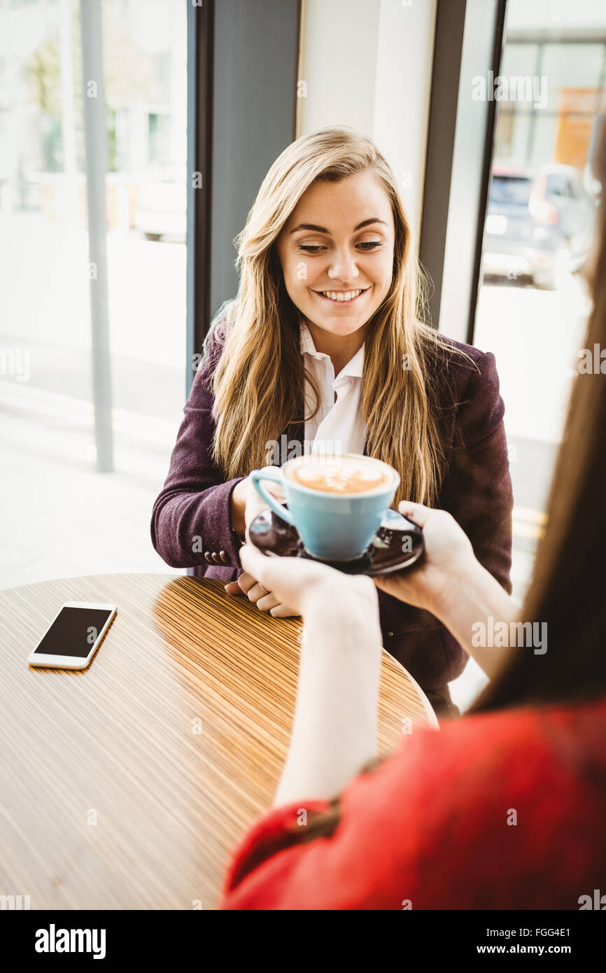Cute blonde girl having a coffee served by her friend Stock Photo - Alamy