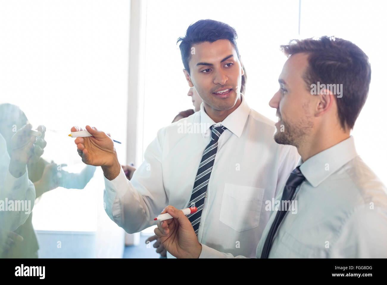 Businesspeople writing on white board Stock Photo