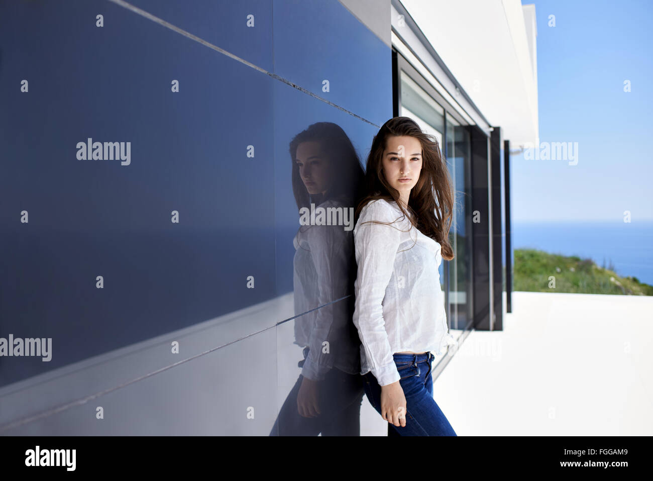relaxed woman in front of luxury modern home Stock Photo - Alamy