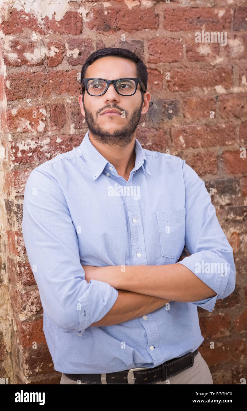 Thoughtful businessman against brick wall Stock Photo Alamy