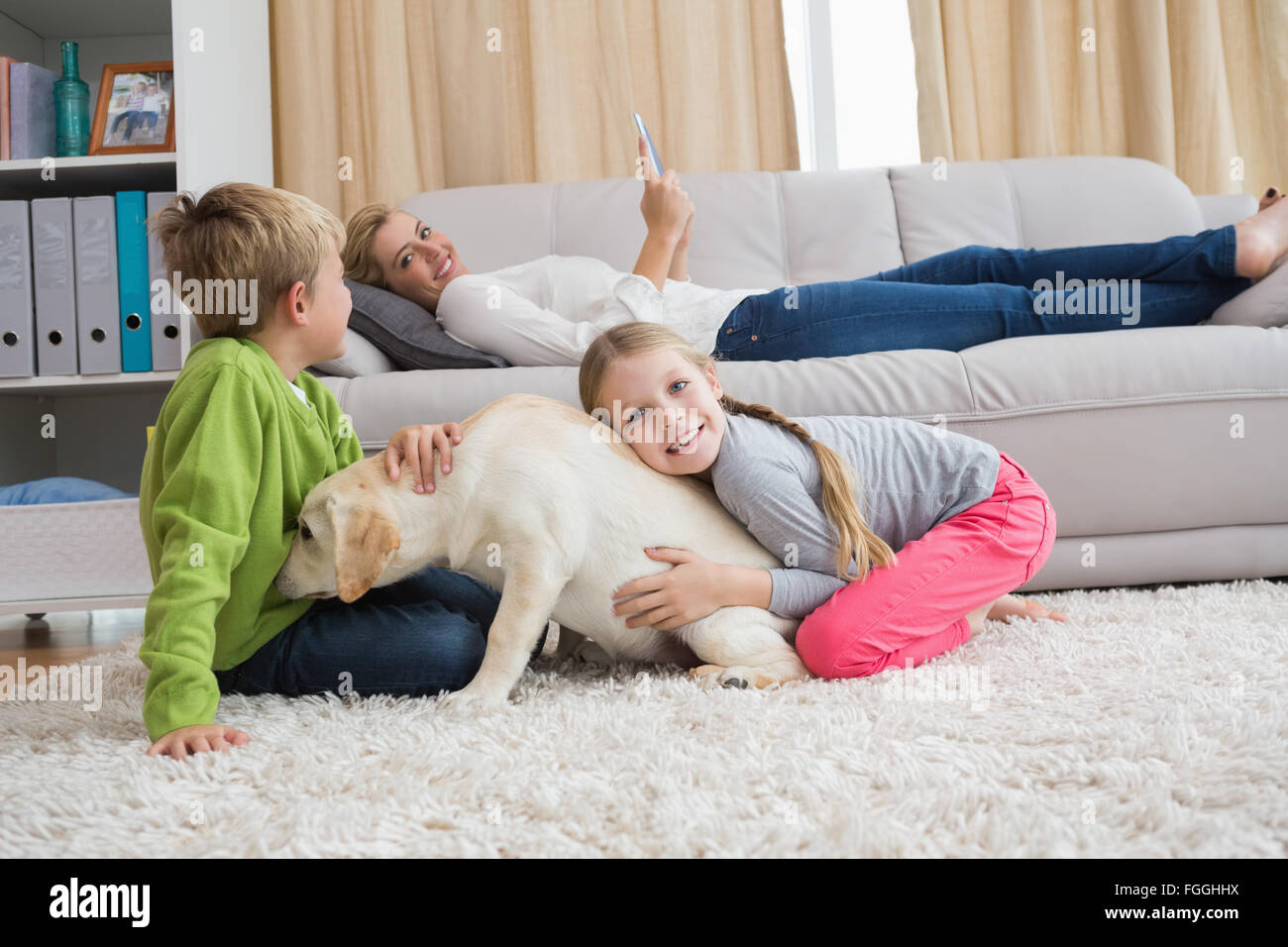 Cute silblings with their puppy on rug Stock Photo Alamy