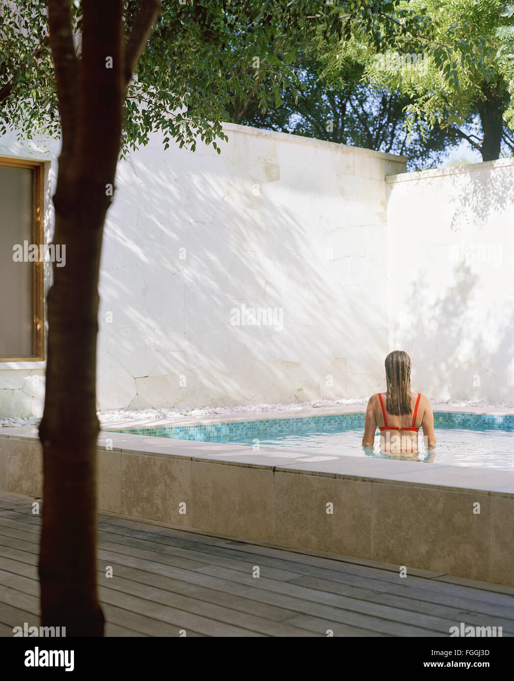 Back view of woman in spa pool. Parrot Cay, Turks and Caicos Stock Photo