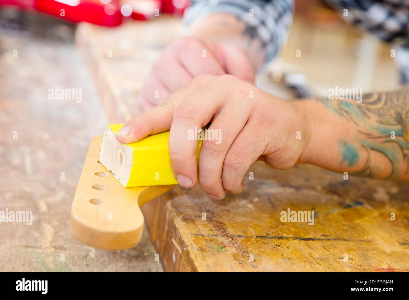 Carpenter sanding a guitar neck in wood at Stock Photo Alamy