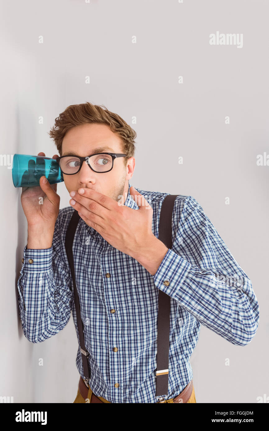 Geeky businessman eavesdropping with cup Stock Photo
