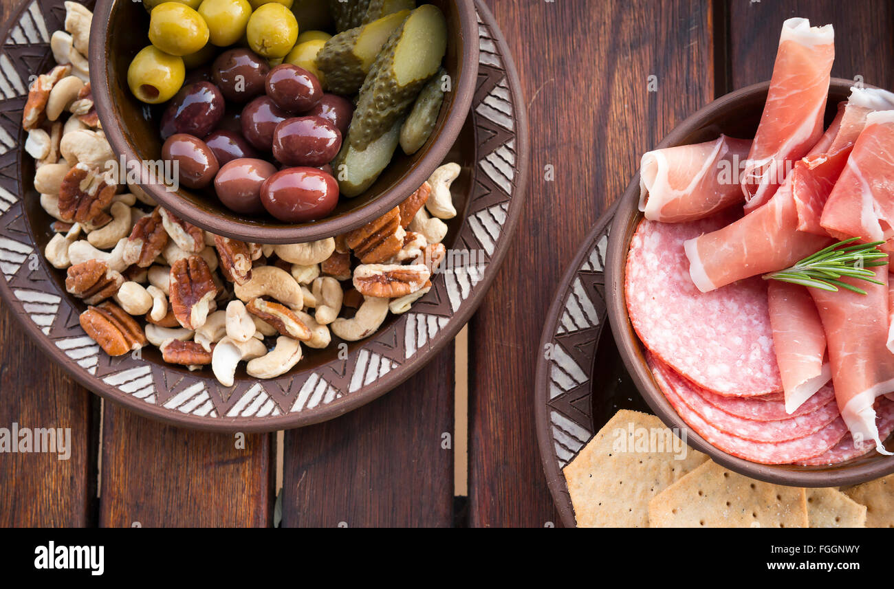 Classic antipasto food platters typical of the Mediterranean including olives, salami, crackers Stock Photo