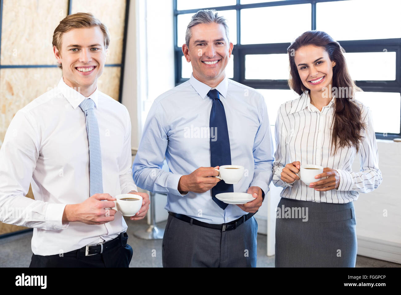 Businesspeople standing together in office Stock Photo - Alamy
