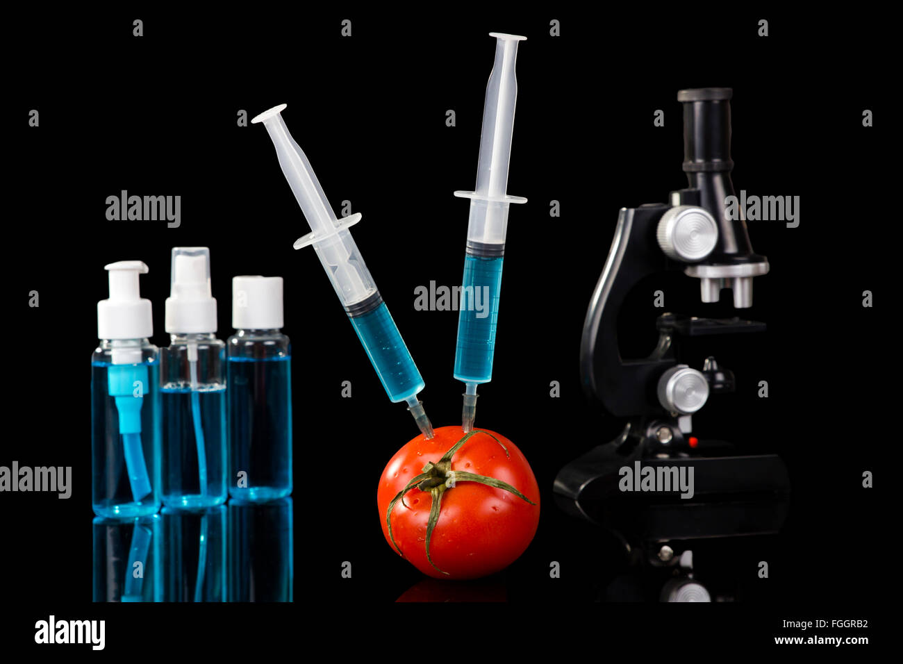 genetically modified vegetables tomato vaccine on black background Stock Photo