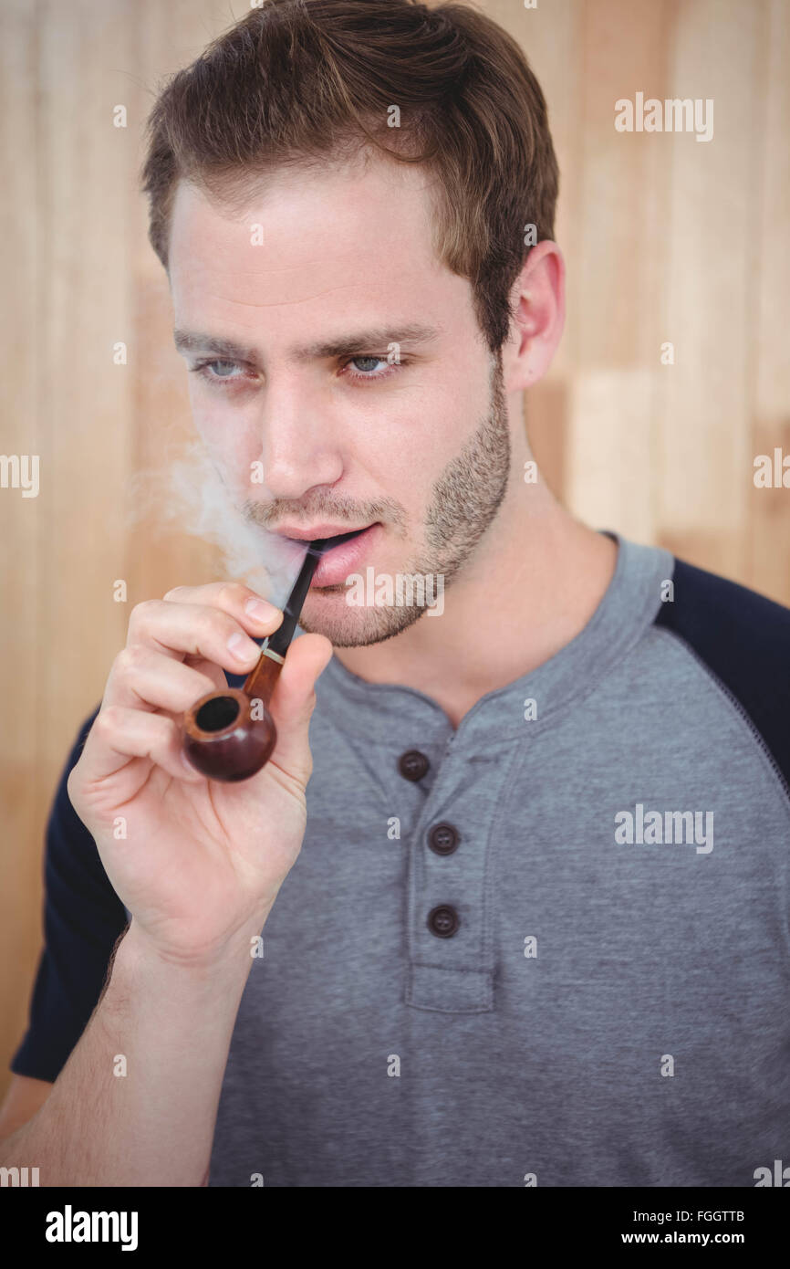 Handsome hipster smoking pipe Stock Photo - Alamy