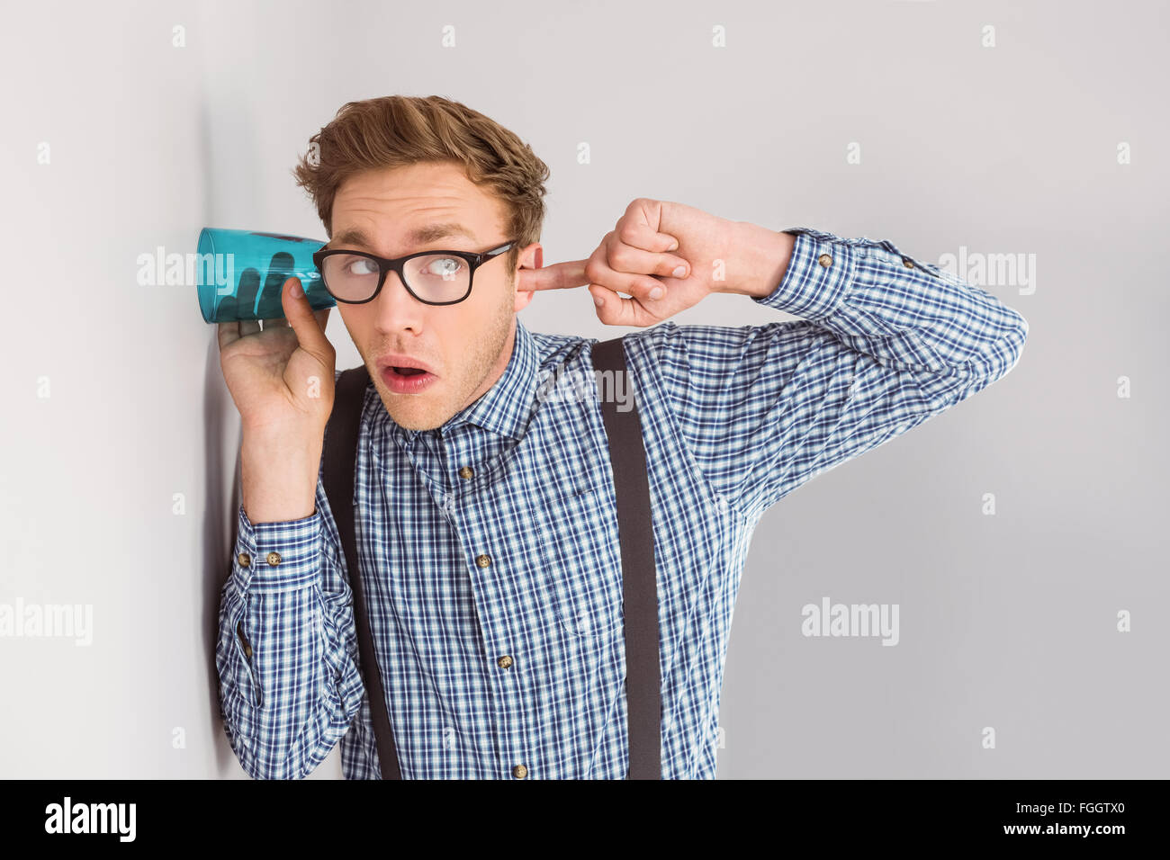 Geeky businessman eavesdropping with cup Stock Photo
