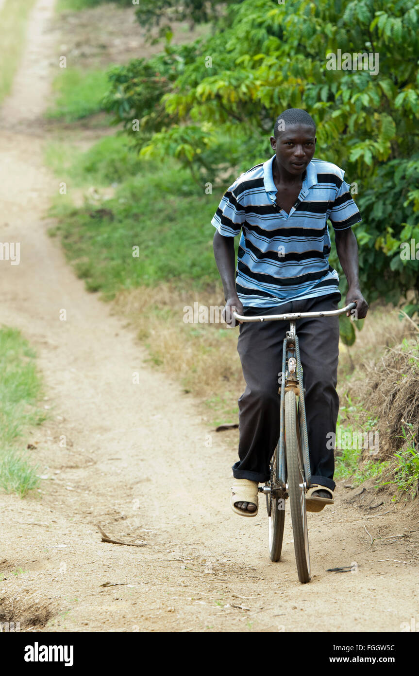 Man on a bicycle, riding along a dust track, Uganda. Stock Photo