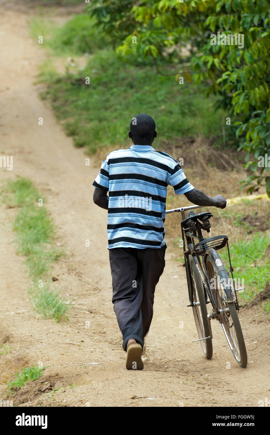 Man pushing a bicycle, along a dust track, Uganda Stock Photo - Alamy