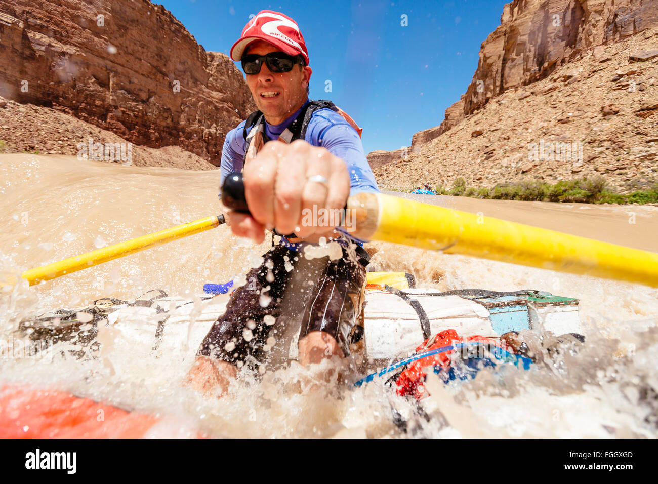 A man is rowing a raft through a rapid on the Colorado River Stock ...
