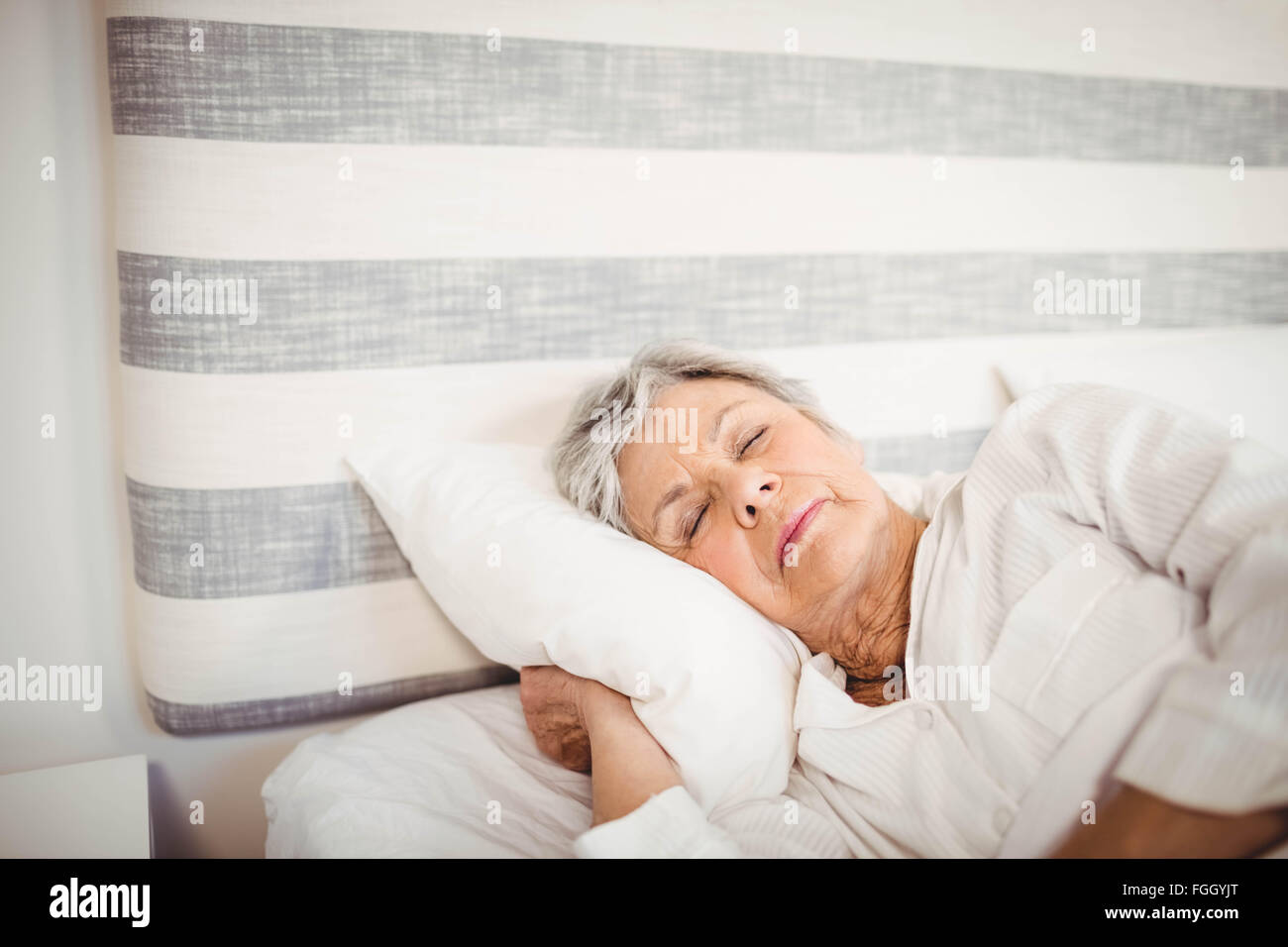 Senior woman sleeping on bed Stock Photo