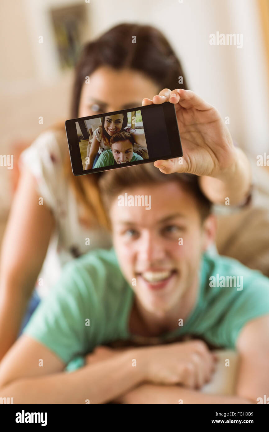 Cute couple taking a selfie on couch Stock Photo - Alamy