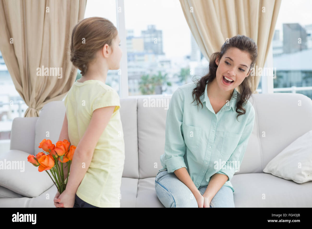 Cute girl hiding flowers from mother Stock Photo