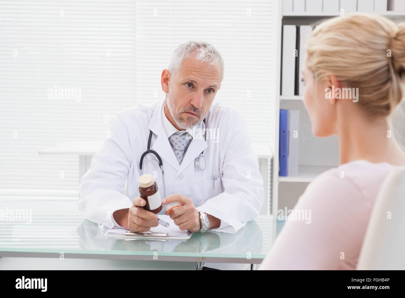 Male doctor giving woman bottle hi-res stock photography and images - Alamy