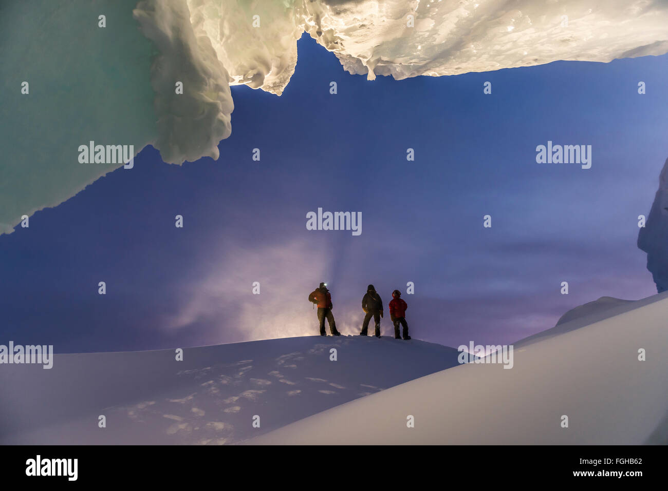 A man stands at the entrance of an ice cave during a winter visit to Antarctica. Stock Photo