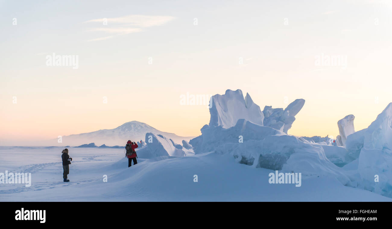 Two people explore the pressure ridges on the sea ice in Antarctica. Stock Photo
