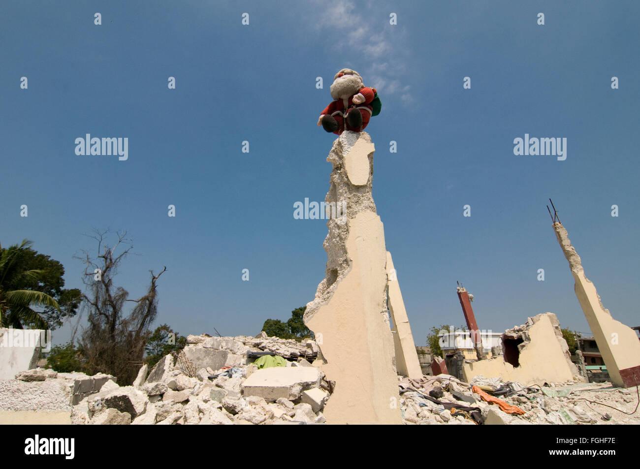 A puppet of Santa Claus sits on a rubble of a building that collapsed ...