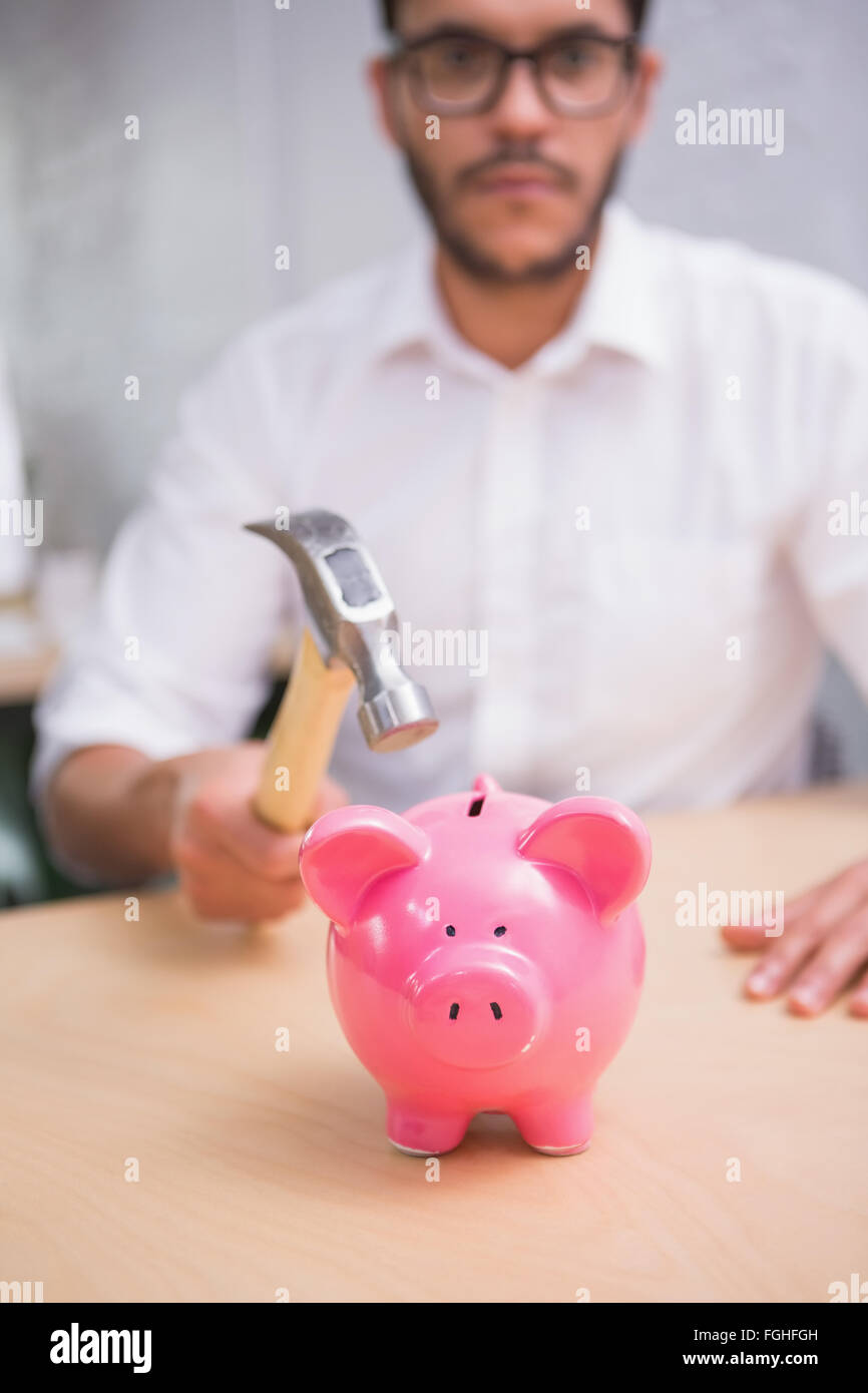 Man breaking piggy bank with hammer Stock Photo - Alamy